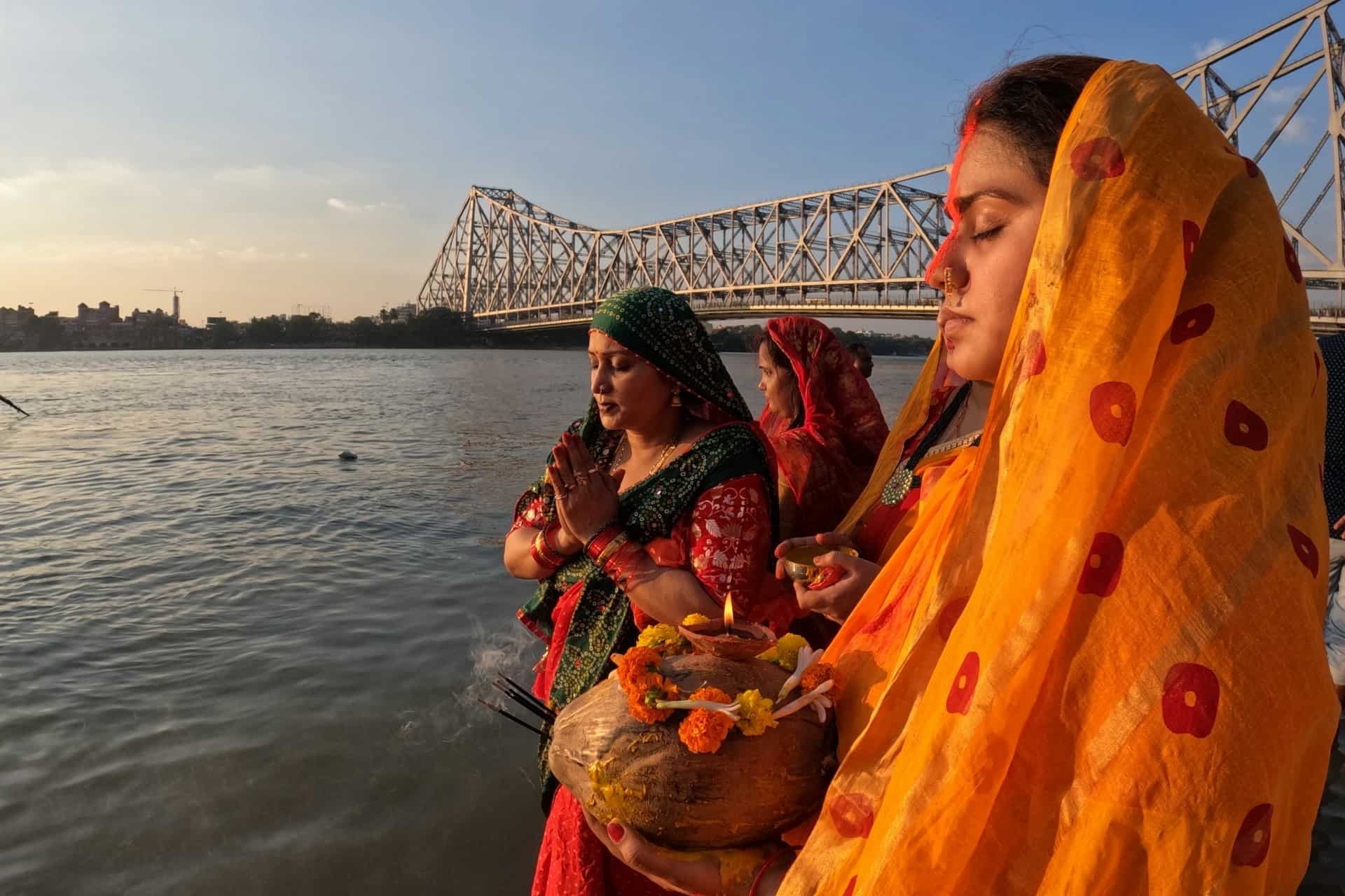 Women Praying with Diyos by the River During Chhath Festival